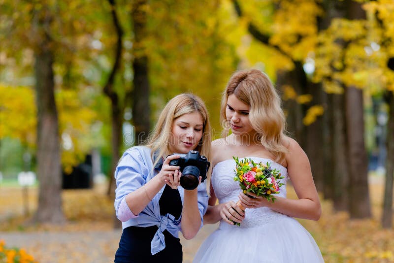 Huwelijksfotograaf die met de bruid onlangs genomen foto's bespreken