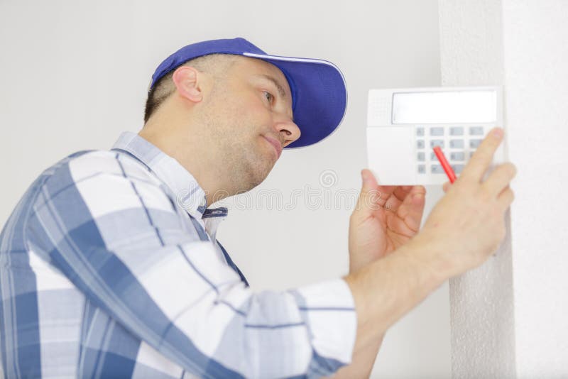 Hvac Technician Installing Faceplate on Digital Thermostat Stock Photo