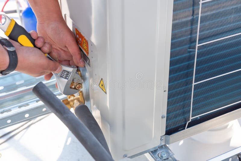 HVAC-tekniker arbetar med luftkonditioneringsanläggningar på ett tak för nya industribyggnader