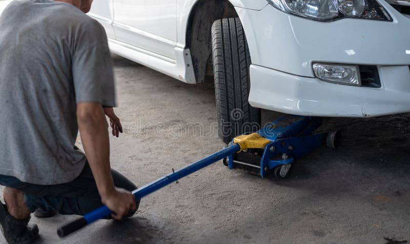 Hydraulic car jack to lift car for check the wheel stock image Hydraulic car jack to lift car for check the wheel stock image