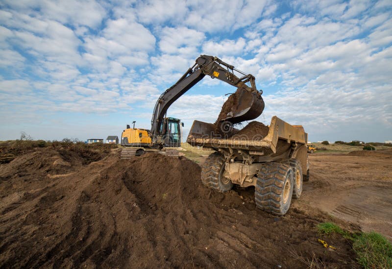 excavators and dumper working as a team on a construction site. excavators and dumper working as a team on a construction site