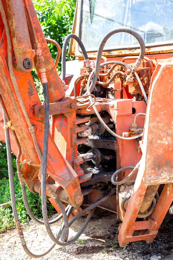 Hydraulic piston system for bulldozers, tractors, excavators, chrome plated cylinder shaft of yellow machine, construction heavy industry detail, selective focus. Hydraulic piston system for bulldozers, tractors, excavators, chrome plated cylinder shaft of yellow machine, construction heavy industry detail, selective focus.