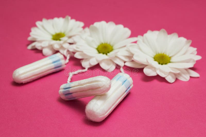 Hygienic tampons and white flowers on a pink background royalty free stock photo Hygienic tampons and white flowers on a pink background royalty free stock photo
