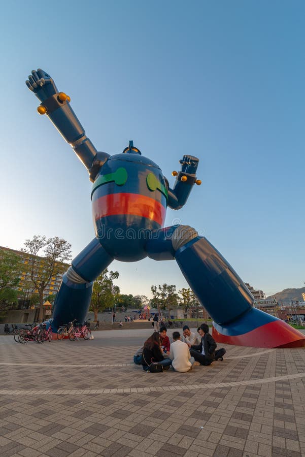 HYOGO NAGATA-KU, KOBE-SHI, JAPÃO 10 DE NOVEMBRO DE 2018: Um grupo de adolescentes japoneses na discussão sob o robô de Tetsujin 28 em Kobe, Japão