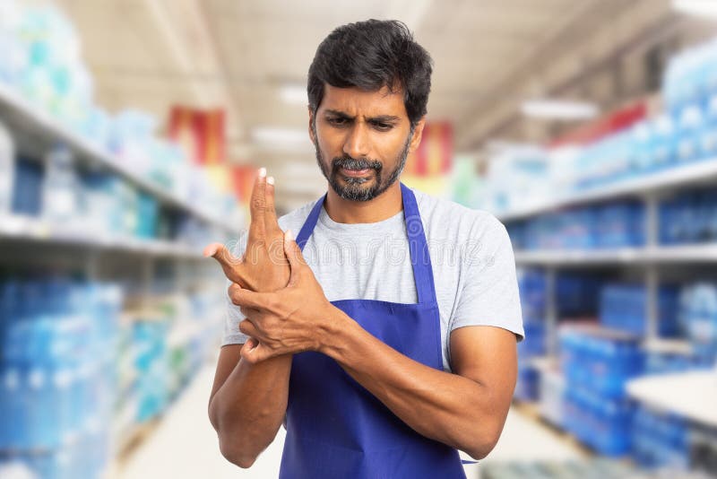 Hypermarket employee touching sprained wrist royalty free stock photos Hypermarket employee touching sprained wrist royalty free stock photos