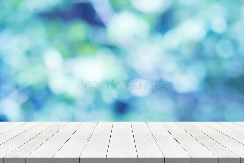 Hölzerne Tischplatte auf blauem unscharfem Hintergrund der Natur für Montage Ihr Produkt lizenzfreie stockbilder