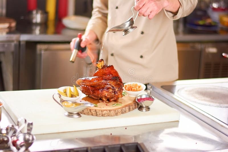 Hällande olja för kock på grillad lammlägg royaltyfri foto Hällande olja för kock på grillad lammlägg royaltyfri foto
