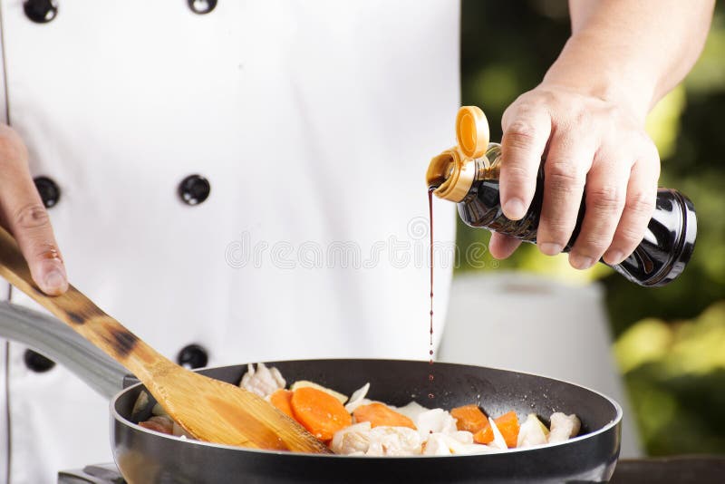 Chef pouring shoyu sauce to the pan for cooking Japanese pork curry / cooking Japanese pork curry paste concept. Chef pouring shoyu sauce to the pan for cooking Japanese pork curry / cooking Japanese pork curry paste concept
