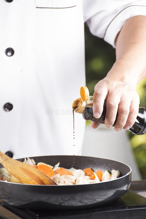 Chef pouring shoyu sauce to the pan for cooking Japanese pork curry / cooking Japanese pork curry paste concept. Chef pouring shoyu sauce to the pan for cooking Japanese pork curry / cooking Japanese pork curry paste concept