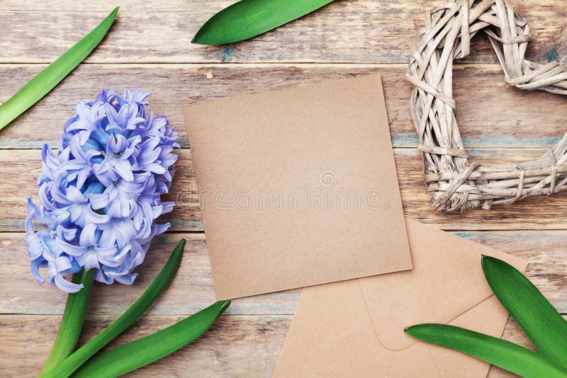 Hälsningkortet på moderdag med det kraft kuvertet dekorerade hyacintblommor och hjärta på lantlig bakgrund Top beskådar