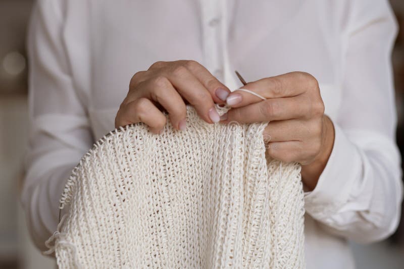 Woman&#x27;s hands knitting brown wool yarn pattern. Closeup horizontal photo. Freelance creative handicraft concept, hobby and lifestyle. Woman&#x27;s hands knitting brown wool yarn pattern. Closeup horizontal photo. Freelance creative handicraft concept, hobby and lifestyle