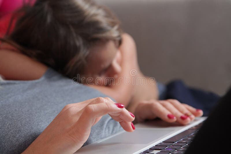 Hände auf dem Computer und im Hintergrund ein schlafendes Baby stockfotos Hände auf dem Computer und im Hintergrund ein schlafendes Baby stockfotos