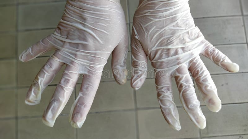 Hände in den chirurgischen Handschuhen. Gesten, die Hände reiben. Hand, die medizinische Handschuhe tragen lizenzfreies stockfoto