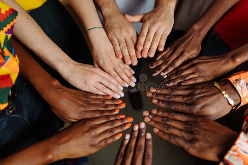 Hände der glücklichen Gruppe multinationaler afrikanischer, lateinamerikanischer und europäischer Menschen, die im Kreis zusammen stockbild Hände der glücklichen Gruppe multinationaler afrikanischer, lateinamerikanischer und europäischer Menschen, die im Kreis zusammen stockbild