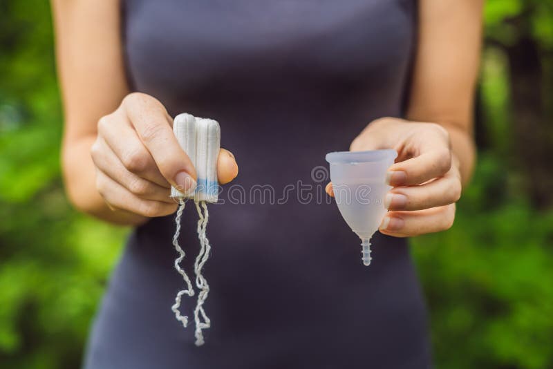 Hände der jungen Frau, die verschiedene Arten von weiblichen Hygieneprodukten - Menstruationsschale und Tampons FAHNE, LANGES FOR lizenzfreie stockfotos Hände der jungen Frau, die verschiedene Arten von weiblichen Hygieneprodukten - Menstruationsschale und Tampons FAHNE, LANGES FOR lizenzfreie stockfotos