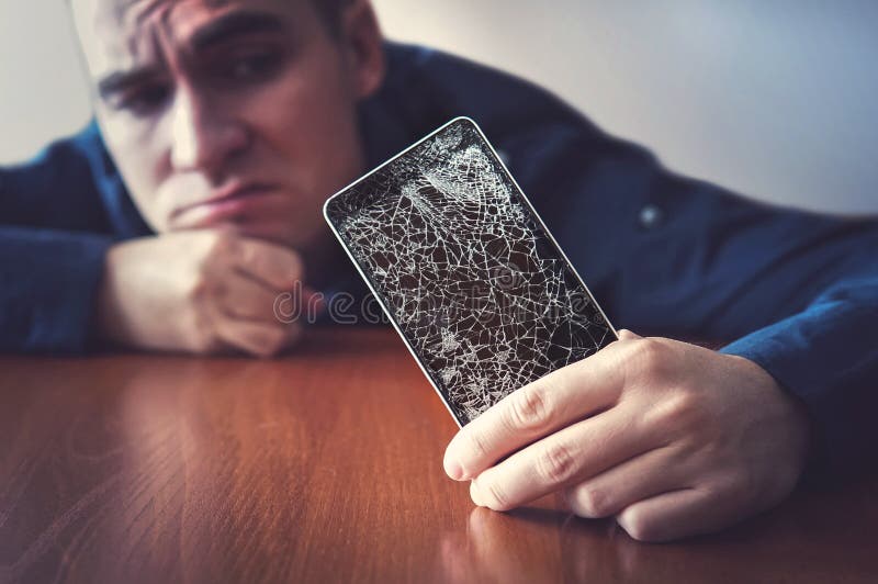 Hände, die einen Handy mit einem defekten Schirm über dem woode halten stockbilder Hände, die einen Handy mit einem defekten Schirm über dem woode halten stockbilder