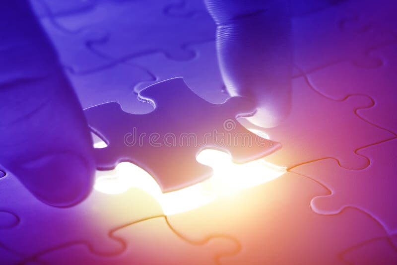 Hände, die letztes Stück eines Puzzlespiels platzieren stockbilder Hände, die letztes Stück eines Puzzlespiels platzieren stockbilder