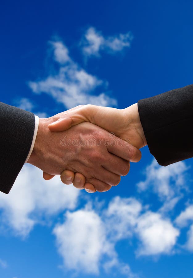 A business hand shake on a summer clouds background. A business hand shake on a summer clouds background