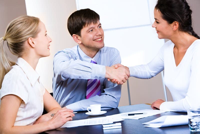 Portrait of woman and man concluding a bargain at business meeting. Portrait of woman and man concluding a bargain at business meeting