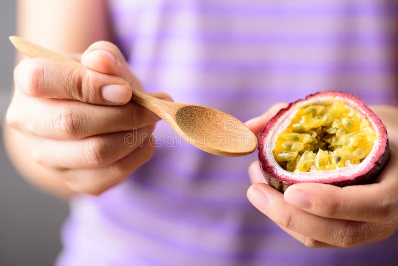 Händelöffel für Frauen zum Verzehr von Passionsfrüchten stockbild Händelöffel für Frauen zum Verzehr von Passionsfrüchten stockbild