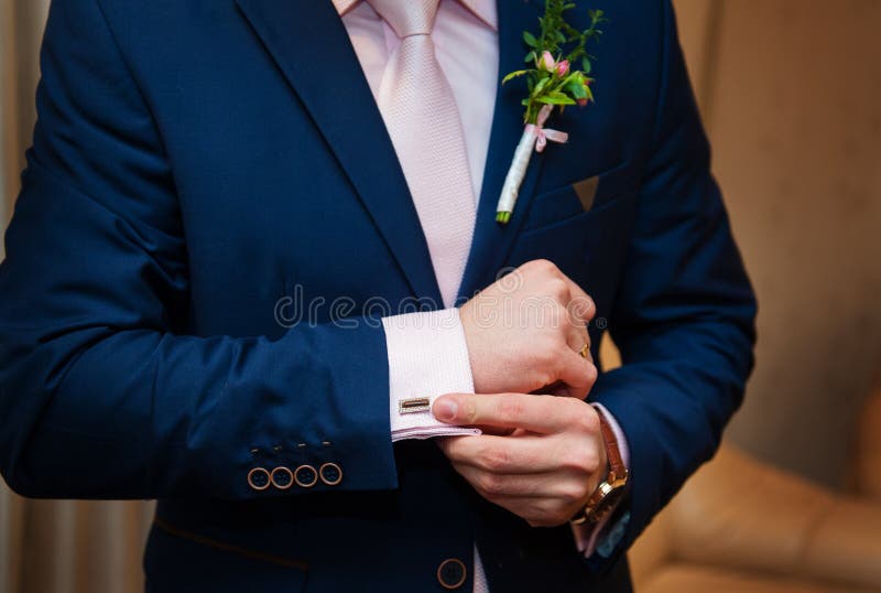 Händer av bröllopbrudgummen i en vit skjorta klär cufflinks royaltyfri foto Händer av bröllopbrudgummen i en vit skjorta klär cufflinks royaltyfri foto