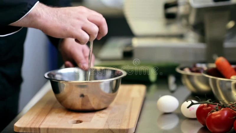 Händer av den manliga kocken lagar mat avbrott av ägget i kök