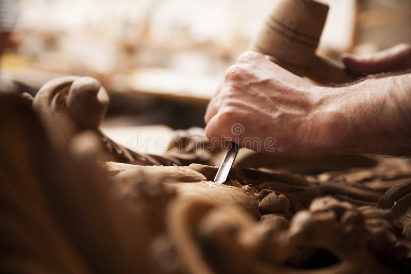 Hands of craftsman carve with a gouge in the hands on the workbench in carpentry. Hands of craftsman carve with a gouge in the hands on the workbench in carpentry