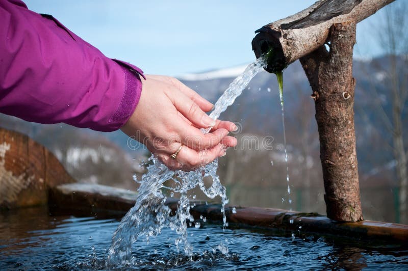 Händer av kvinnan i den naturliga springbrunnen på berget royaltyfri foto Händer av kvinnan i den naturliga springbrunnen på berget royaltyfri foto