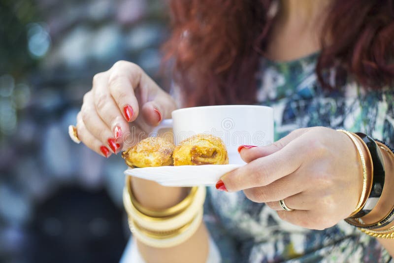 Händer för kvinna` s med guld- armband, cirklar, koppen kaffe och a royaltyfri foto Händer för kvinna` s med guld- armband, cirklar, koppen kaffe och a royaltyfri foto