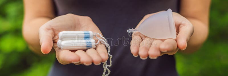 Händer för ung kvinna som rymmer olika typer av kvinnliga hygienprodukter - menstruations- kopp- och tampongBANER, LÅNGT FORMAT royaltyfri bild Händer för ung kvinna som rymmer olika typer av kvinnliga hygienprodukter - menstruations- kopp- och tampongBANER, LÅNGT FORMAT royaltyfri bild
