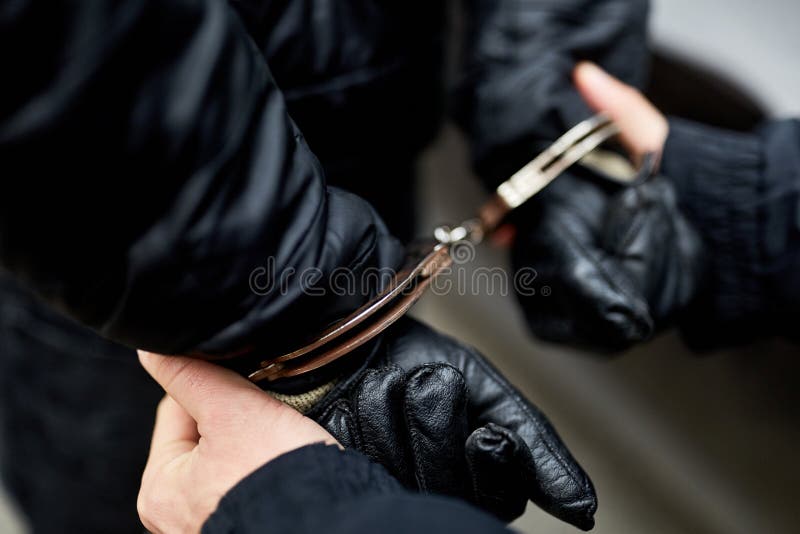 Händer som handfängslas bak tillbaka arkivbilder Händer som handfängslas bak tillbaka arkivbilder