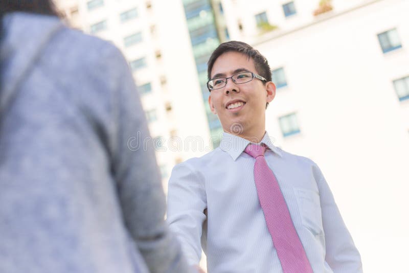 Händeschütteln des asiatischen Mannes und der Frauen des Geschäfts im Freien mit buildin lizenzfreie stockbilder Händeschütteln des asiatischen Mannes und der Frauen des Geschäfts im Freien mit buildin lizenzfreie stockbilder