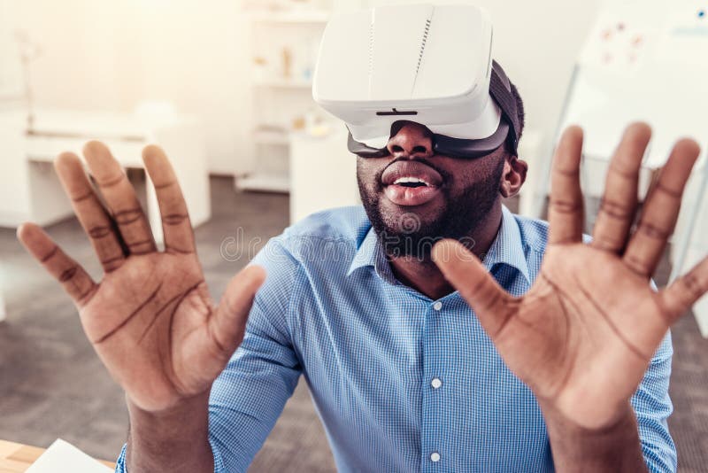Häpen ung man som tycker om virtuell verklighetexponeringsglas royaltyfri bild Häpen ung man som tycker om virtuell verklighetexponeringsglas royaltyfri bild