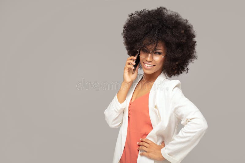 Härlig afro kvinna som talar vid mobiltelefonen arkivbild Härlig afro kvinna som talar vid mobiltelefonen arkivbild