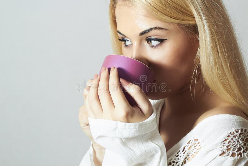 Härlig blond kvinna som dricker kaffe. Dunstkopp te