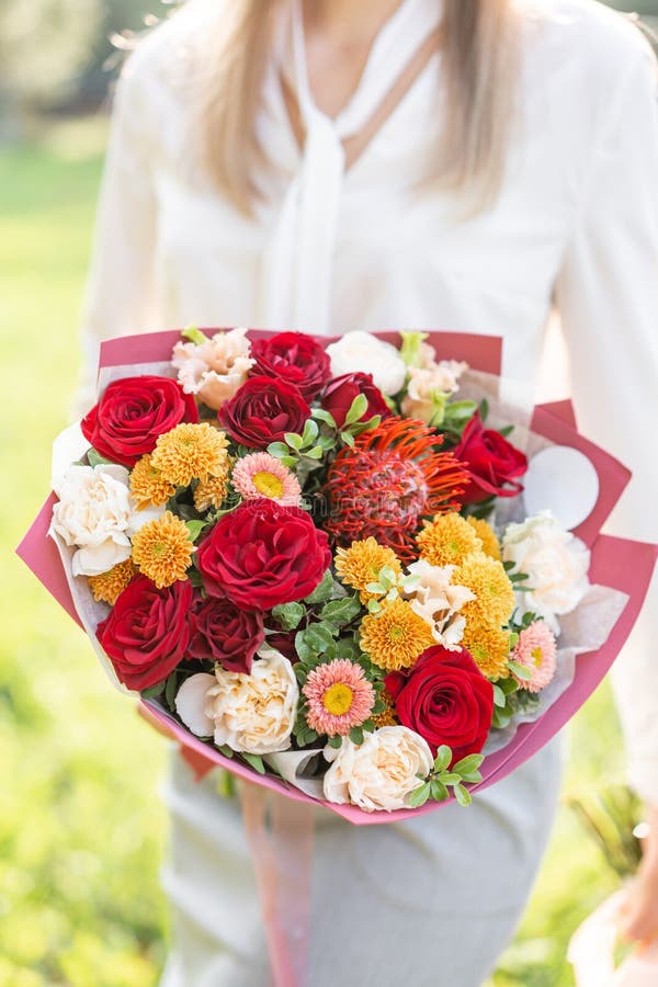 härlig bukett Ung flicka rymma blommaordningar med variation av färger Ljus gryning- eller solnedgångsol royaltyfria foton härlig bukett Ung flicka rymma blommaordningar med variation av färger Ljus gryning- eller solnedgångsol royaltyfria foton