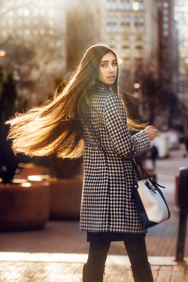 Härlig elegant brunettkvinna med långt hår som går i staden fotografering för bildbyråer Härlig elegant brunettkvinna med långt hår som går i staden fotografering för bildbyråer