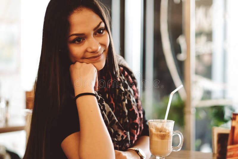 Härlig flicka som dricker ismockaskakan i ett kafé royaltyfri foto Härlig flicka som dricker ismockaskakan i ett kafé royaltyfri foto