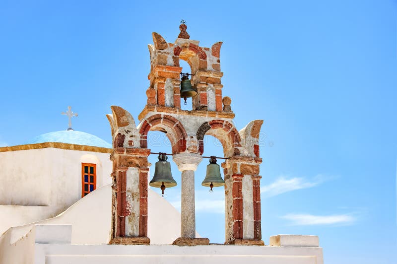 Härlig gammal ortodox vit kyrka med den blåa kupolen och den gamla bågen med klockor mot den blåa himlen, Santorini, Grekland, Eu arkivfoton Härlig gammal ortodox vit kyrka med den blåa kupolen och den gamla bågen med klockor mot den blåa himlen, Santorini, Grekland, Eu arkivfoton
