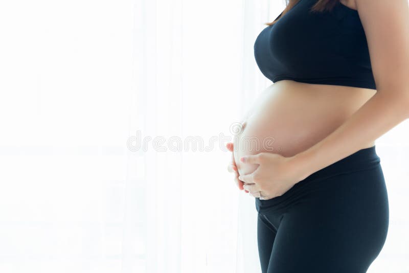 Härlig gravid kvinnainnehavbuk, genom att använda händer Attraktiv härlig gravid flicka- eller mammaförälskelse behandla som ett fotografering för bildbyråer Härlig gravid kvinnainnehavbuk, genom att använda händer Attraktiv härlig gravid flicka- eller mammaförälskelse behandla som ett fotografering för bildbyråer