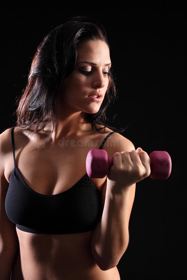 härlig kvinna för idrottshall för bicepkrullningsövning arkivfoto härlig kvinna för idrottshall för bicepkrullningsövning arkivfoto
