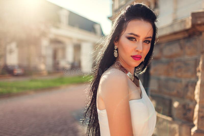 Härlig kvinna med den bärande vita bröllopsklänningen för långt hår utomhus Skönhetmodemodell med smycken och makeup royaltyfria bilder Härlig kvinna med den bärande vita bröllopsklänningen för långt hår utomhus Skönhetmodemodell med smycken och makeup royaltyfria bilder