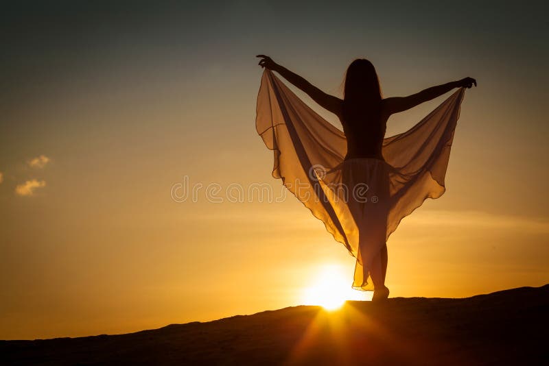 Härlig kvinna som poserar på solnedgången