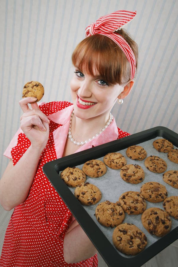 Retro housewife holding cookie tray full of chocolate cookie. Retro housewife holding cookie tray full of chocolate cookie