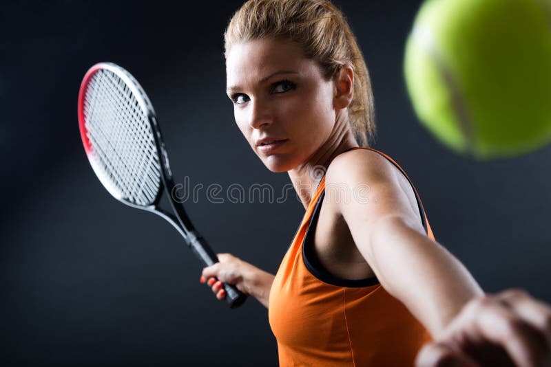 Härlig kvinna som spelar tennis inomhus Isolerat på svart royaltyfri bild Härlig kvinna som spelar tennis inomhus Isolerat på svart royaltyfri bild