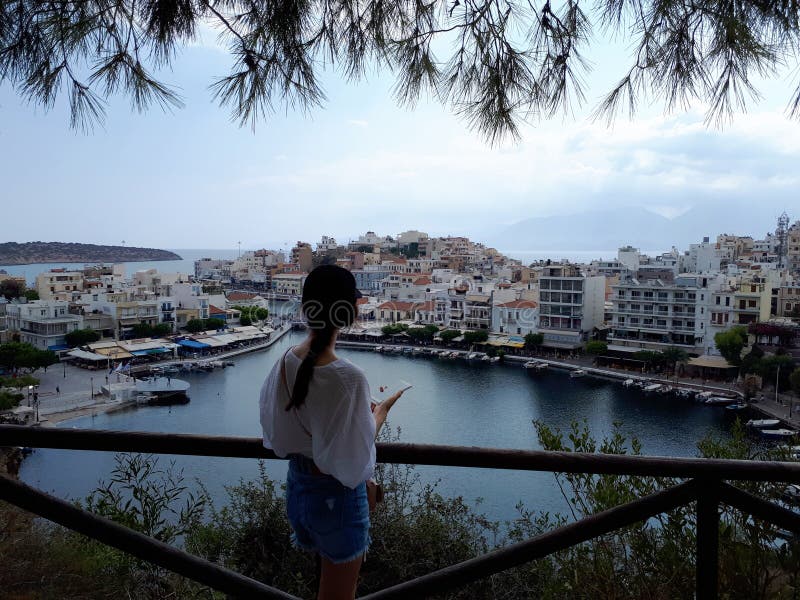 Härlig kvinna som tycker om sjösikt i Agios Nikolaos, Kreta, Grekland royaltyfria bilder Härlig kvinna som tycker om sjösikt i Agios Nikolaos, Kreta, Grekland royaltyfria bilder