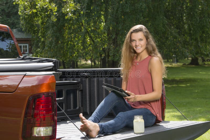 Härlig landsflicka på baksida av varubillastbilen arkivbild Härlig landsflicka på baksida av varubillastbilen arkivbild