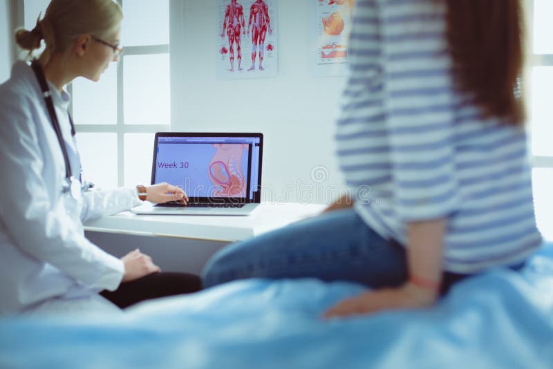 Härlig le gravid kvinna med doktorn på sjukhuset arkivfoto Härlig le gravid kvinna med doktorn på sjukhuset arkivfoto