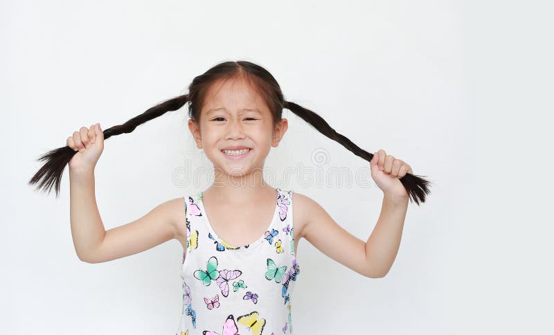 H?rlig liten asiatisk r?ttsvans f?r barnflickainnehav p? vit bakgrund St?ende som ler barn med tv? r?ttsvansar fotografering för bildbyråer H?rlig liten asiatisk r?ttsvans f?r barnflickainnehav p? vit bakgrund St?ende som ler barn med tv? r?ttsvansar fotografering för bildbyråer