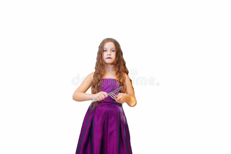 Härlig liten flicka med långt hår i klänning, ståenden poserar med känslomässigt en kniv, och gaffeln för afton som isoleras arkivfoto Härlig liten flicka med långt hår i klänning, ståenden poserar med känslomässigt en kniv, och gaffeln för afton som isoleras arkivfoto